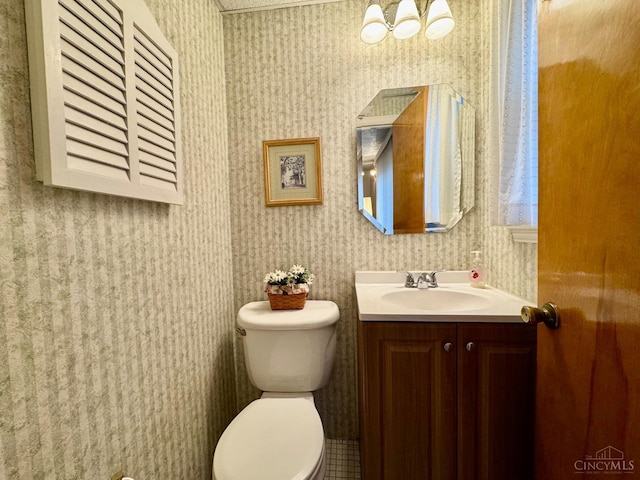 half bathroom featuring wallpapered walls, vanity, toilet, and a chandelier