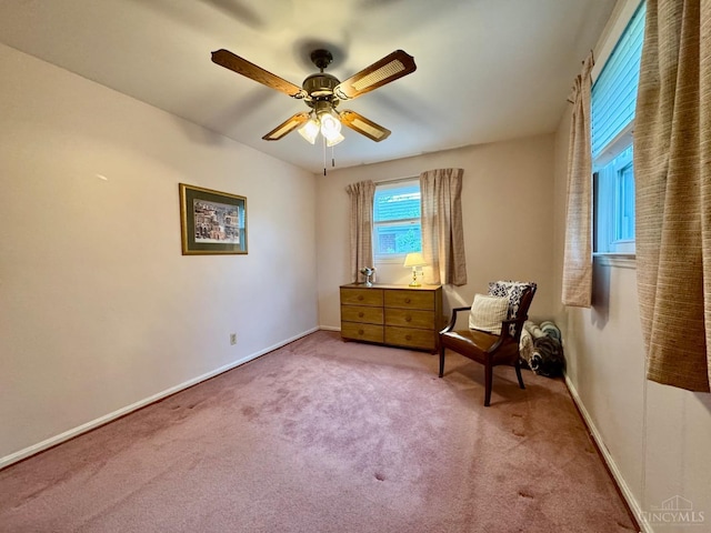 living area featuring carpet, a ceiling fan, and baseboards