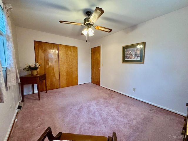 unfurnished bedroom with a closet, carpet flooring, a ceiling fan, and baseboards