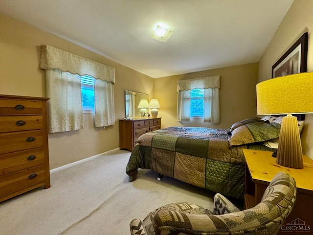 bedroom featuring light colored carpet and baseboards