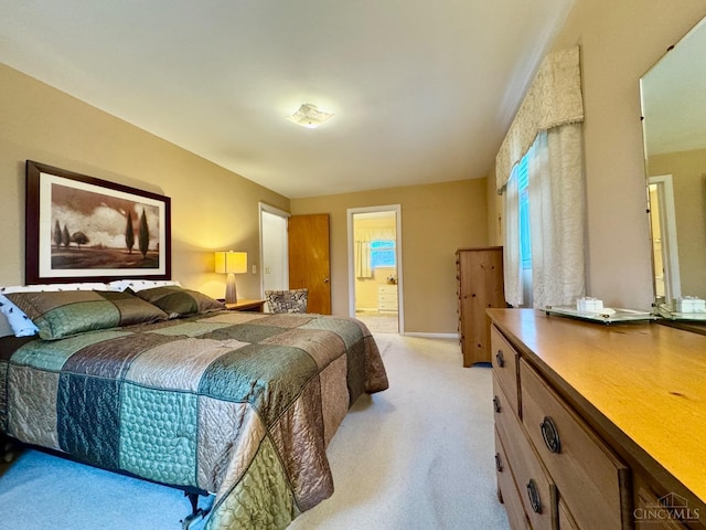 bedroom with light colored carpet and connected bathroom