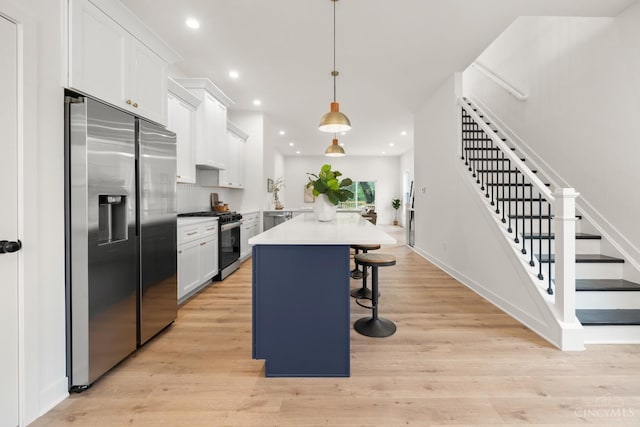 kitchen featuring appliances with stainless steel finishes, a kitchen bar, white cabinetry, recessed lighting, and backsplash