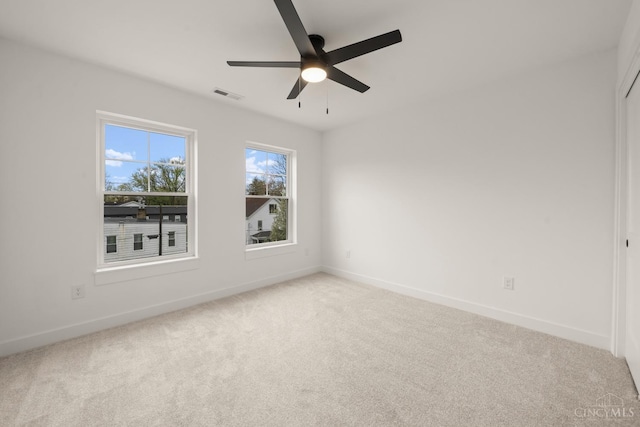 carpeted empty room with baseboards and a ceiling fan