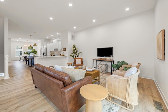 living area with light wood-type flooring, baseboards, and recessed lighting