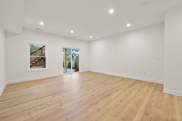 empty room with recessed lighting, light wood-style flooring, and baseboards