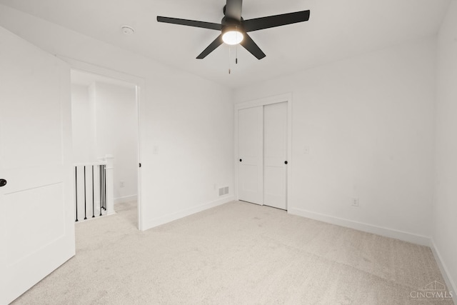 unfurnished room featuring light colored carpet, baseboards, and a ceiling fan