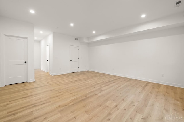 below grade area with recessed lighting, light wood-type flooring, and baseboards