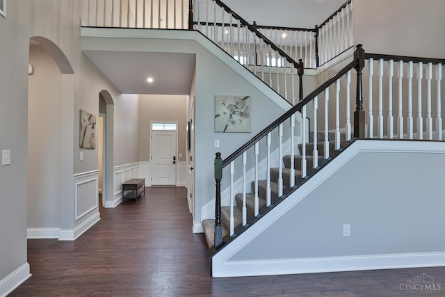 7690 Wharton Ct, West Chester, OH 45069 - stairs with wood finished floors, arched walkways, and a towering ceiling