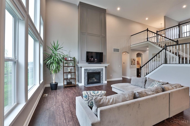 7690 Wharton Ct, West Chester, OH 45069 - living area featuring a towering ceiling, stairs, arched walkways, dark wood finished floors, and a fireplace
