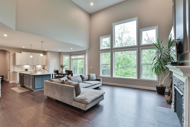 7690 Wharton Ct, West Chester, OH 45069 - living area featuring dark wood-type flooring, arched walkways, a towering ceiling, a tiled fireplace, and recessed lighting