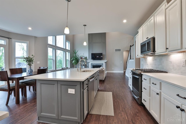 7690 Wharton Ct, West Chester, OH 45069 - kitchen with stainless steel appliances, gray cabinetry, light countertops, backsplash, and dark wood-style flooring