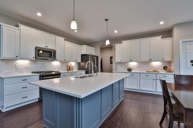 7690 Wharton Ct, West Chester, OH 45069 - kitchen with stainless steel appliances, arched walkways, dark wood finished floors, backsplash, and light countertops