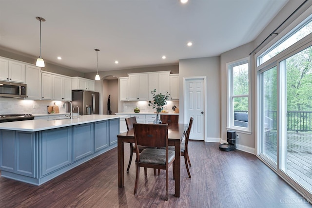7690 Wharton Ct, West Chester, OH 45069 - kitchen with appliances with stainless steel finishes, decorative backsplash, white cabinetry, light countertops, and dark wood-style floors