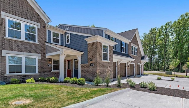 5880 Parkview Ln Unit 303, Miami Twp, OH 45150 - view of front of home with an attached garage, concrete driveway, brick siding, and a front lawn