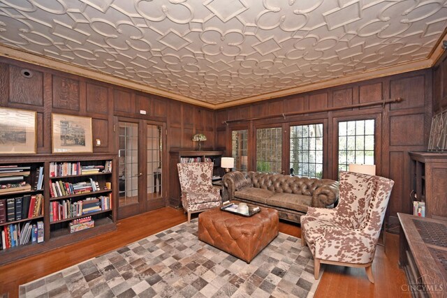 1 Beech Crest Ln, Cincinnati, OH 45206 - living room with wood walls, wood finished floors, crown molding, an ornate ceiling, and french doors
