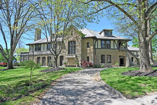 1 Beech Crest Ln, Cincinnati, OH 45206 - tudor-style house featuring stone siding, a front yard, asphalt driveway, and a chimney