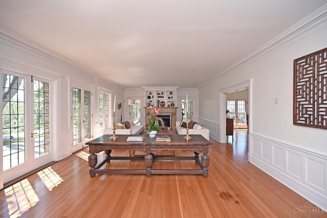 1 Beech Crest Ln, Cincinnati, OH 45206 - living room featuring french doors, light wood-style flooring, a wainscoted wall, plenty of natural light, and a fireplace