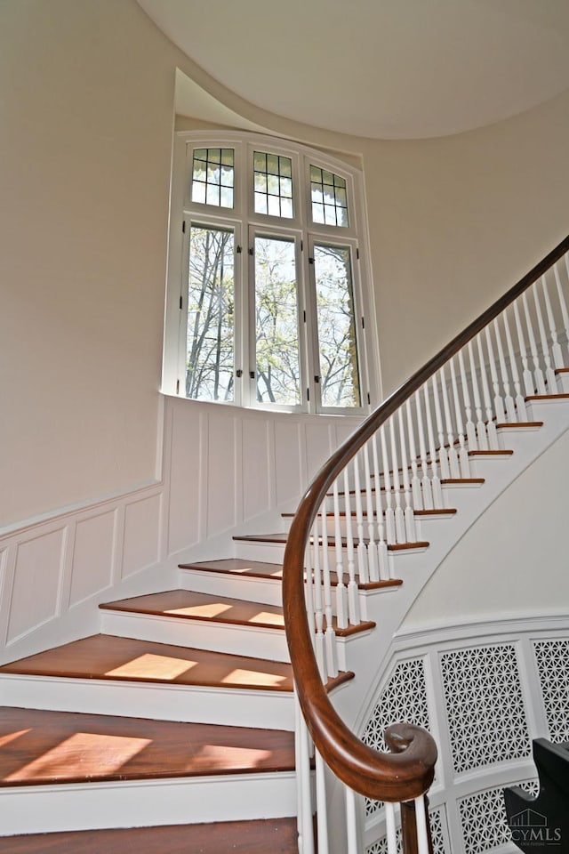 1 Beech Crest Ln, Cincinnati, OH 45206 - stairs featuring a decorative wall, healthy amount of natural light, a wainscoted wall, and french doors