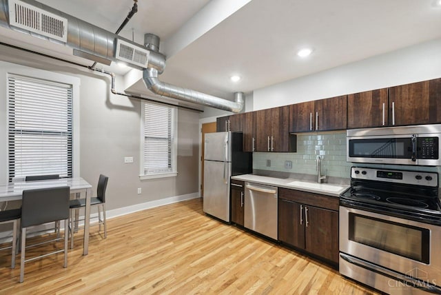 1406 Republic St Unit 102, Cincinnati, OH 45202 - kitchen with appliances with stainless steel finishes, a sink, dark brown cabinetry, light countertops, and light wood-type flooring