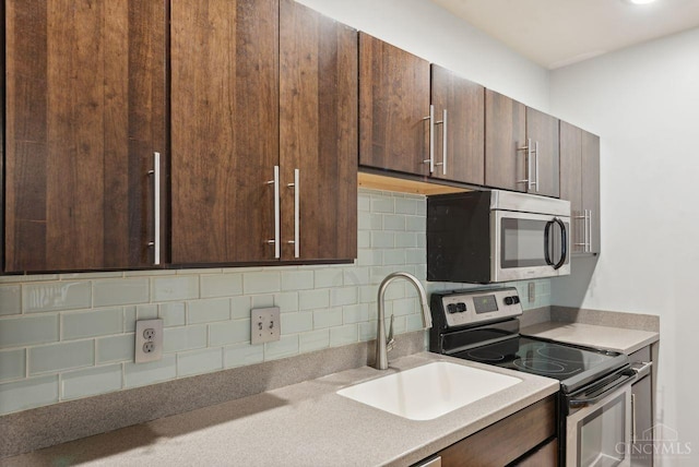 1406 Republic St Unit 102, Cincinnati, OH 45202 - kitchen featuring stainless steel appliances, a sink, backsplash, and dark brown cabinets