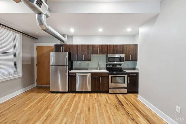 1406 Republic St Unit 102, Cincinnati, OH 45202 - kitchen featuring appliances with stainless steel finishes, a sink, light countertops, dark brown cabinetry, and baseboards