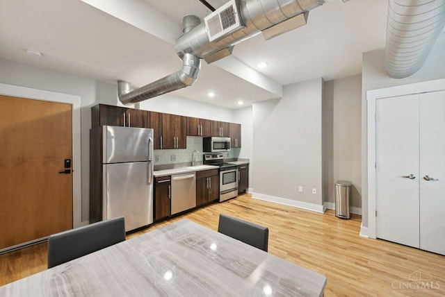 1406 Republic St Unit 102, Cincinnati, OH 45202 - kitchen with appliances with stainless steel finishes, a sink, baseboards, dark brown cabinets, and light countertops
