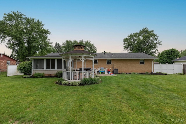 8588 Twincreek Dr, Franklin Twp, OH 45005 - back of property at dusk with a sunroom, a patio, and brick siding