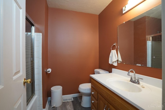 1260 Pine Forest Dr, Pierce Twp, OH 45102 - full bath with toilet, wood finished floors, vanity, a textured ceiling, and combined bath / shower with glass door