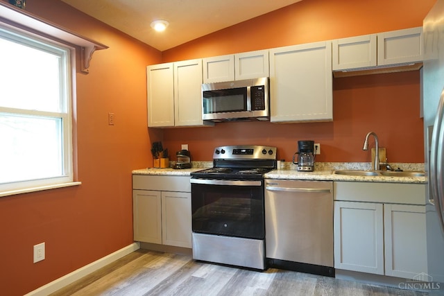 1260 Pine Forest Dr, Pierce Twp, OH 45102 - kitchen with stainless steel appliances, a sink, vaulted ceiling, light wood-style floors, and baseboards