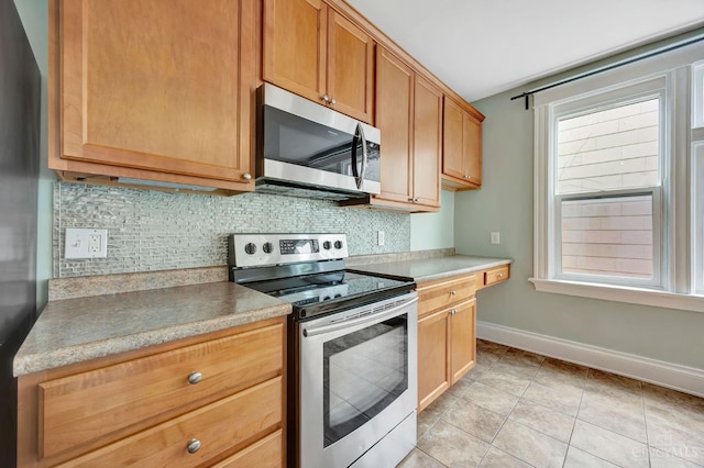 4604 Simpson Ave, Cincinnati, OH 45227 - kitchen featuring stainless steel appliances, tasteful backsplash, baseboards, and light tile patterned floors