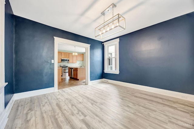 4604 Simpson Ave, Cincinnati, OH 45227 - unfurnished room with a chandelier, light wood finished floors, a sink, and baseboards