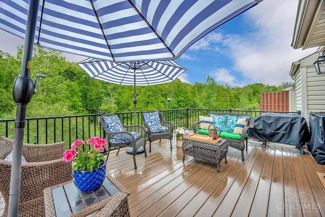 wooden terrace featuring outdoor lounge area, area for grilling, and a forest view