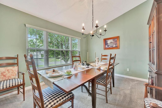 dining room with a chandelier, baseboards, light colored carpet, and lofted ceiling