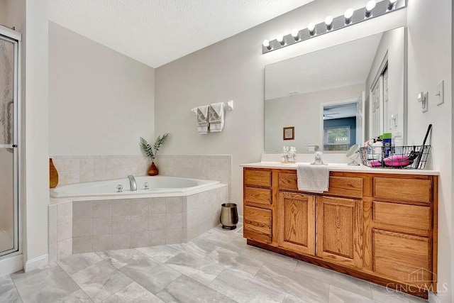 bathroom with a bath, vanity, and a shower stall