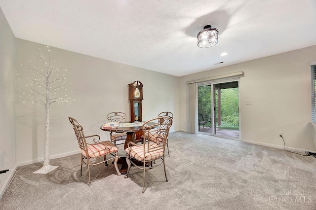 dining space featuring light colored carpet and baseboards