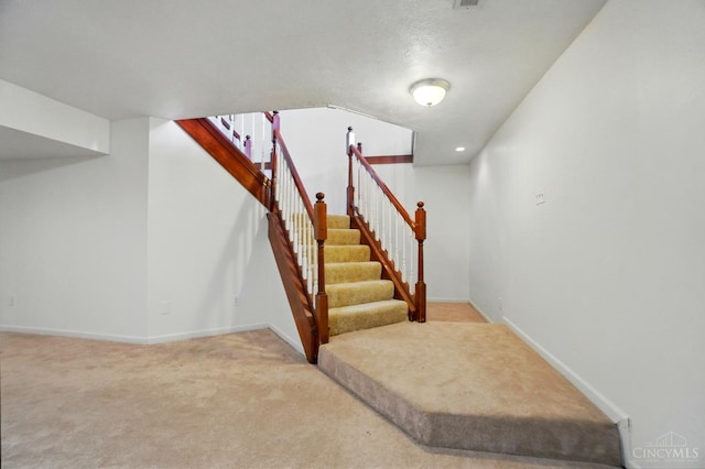 stairs featuring carpet and baseboards