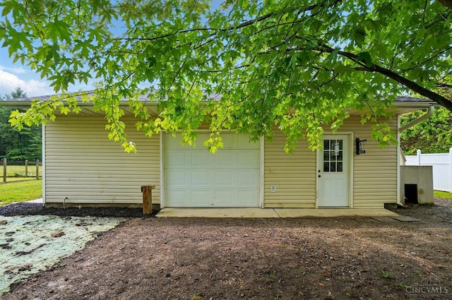 garage featuring fence and driveway