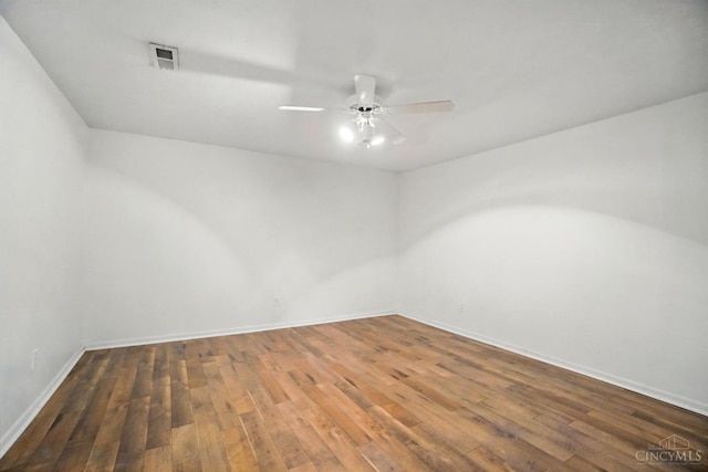 spare room with wood-type flooring, ceiling fan, and baseboards