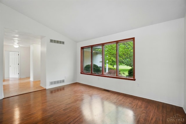 unfurnished room featuring wood finished floors, lofted ceiling, and baseboards