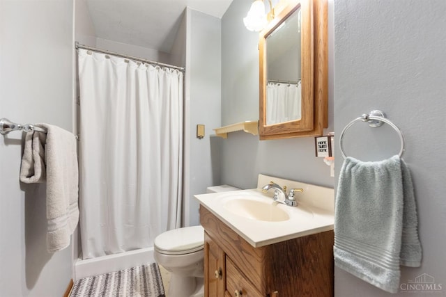 full bathroom featuring vanity, a shower stall, and toilet