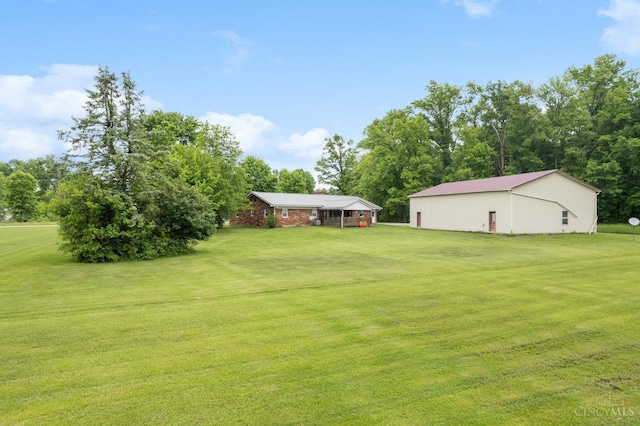 view of grassy yard featuring a pole building and an outdoor structure