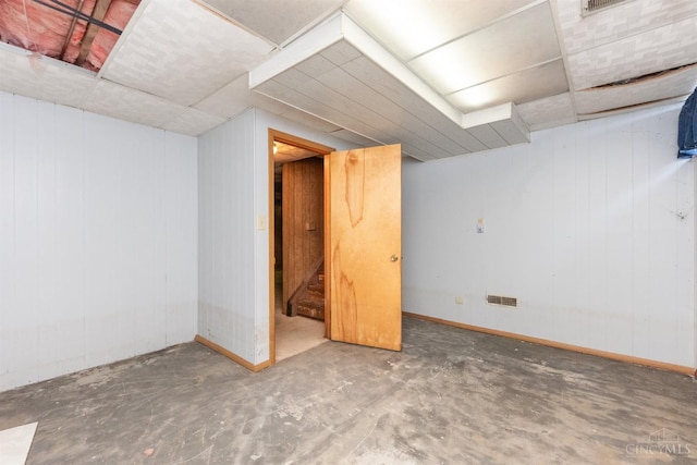 finished below grade area with baseboards and wooden walls