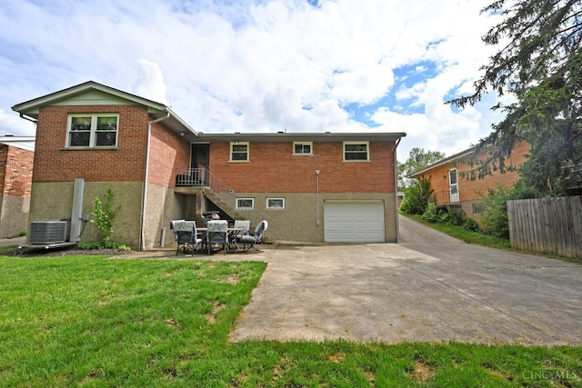5638 Victoryview Ln, Delhi Twp, OH 45233 - back of property with an attached garage, driveway, brick siding, and central air condition unit