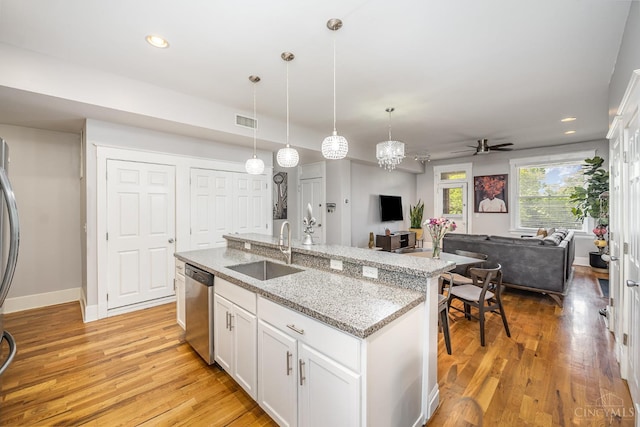 709 E Mcmillan St Unit 1, Cincinnati, OH 45206 - kitchen featuring a sink, stainless steel appliances, open floor plan, white cabinets, and a ceiling fan
