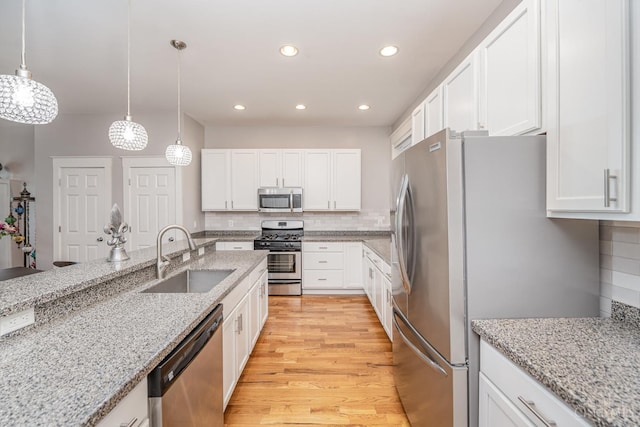 709 E Mcmillan St Unit 1, Cincinnati, OH 45206 - kitchen featuring stainless steel appliances, a sink, light wood finished floors, white cabinetry, and recessed lighting