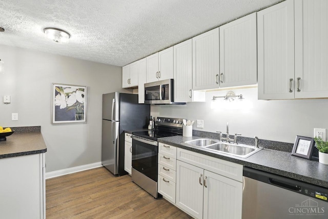 6607 Hearne Rd Unit 90, Green Twp, OH 45248 - kitchen with appliances with stainless steel finishes, a sink, dark countertops, dark wood finished floors, and baseboards