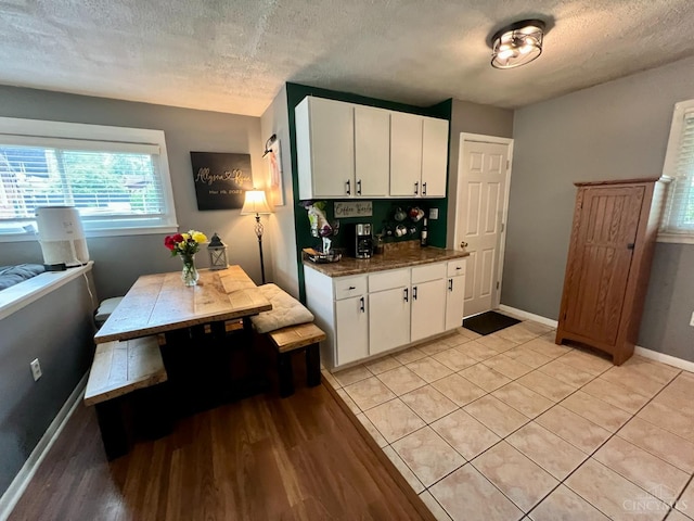 8608 Dundalk Ct, Sycamore Twp, OH 45236 - kitchen featuring a textured ceiling, white cabinetry, dark countertops, baseboards, and light wood finished floors