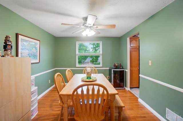 12056 Hazelhurst Ln, Springfield Twp, OH 45240 - dining area featuring beverage cooler, light wood-style flooring, ceiling fan, and baseboards