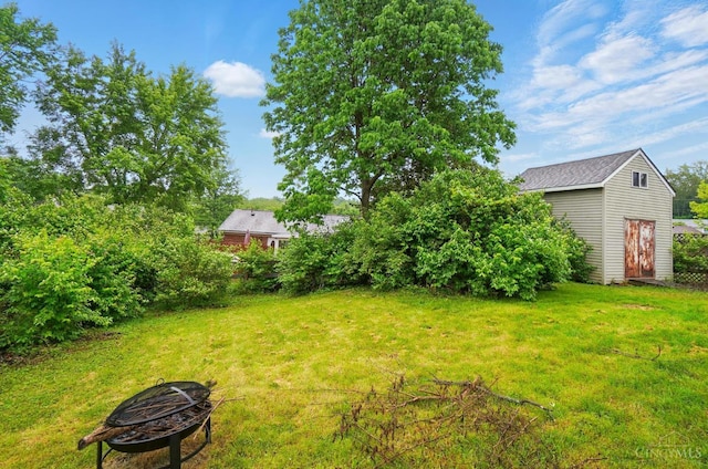 12056 Hazelhurst Ln, Springfield Twp, OH 45240 - view of grassy yard with a fire pit, a shed, and an outbuilding