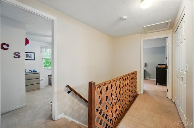 12056 Hazelhurst Ln, Springfield Twp, OH 45240 - hallway with an upstairs landing, light carpet, attic access, baseboards, and a textured ceiling